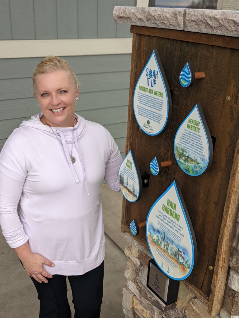 person standing next to award sign on property