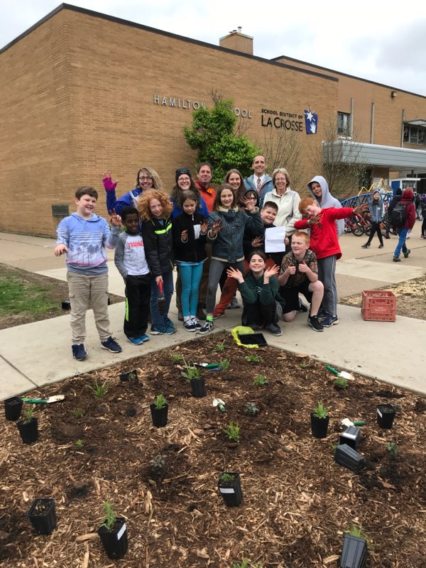 Students, staff, and community volunteers got their hands dirty, laying mulch and planting this rain garden.